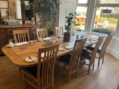a dining room table with chairs and a large wooden table at Ravenswood Guest House in Stirling