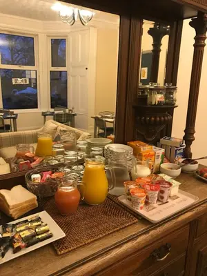 a table with a bunch of food and orange juice at Ravenswood Guest House in Stirling