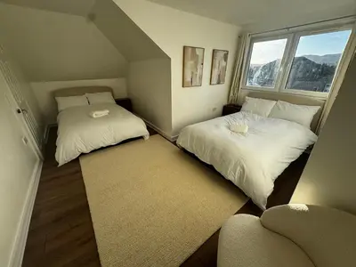 a small room with two beds and a rug at 4BR Home near Airport & City Centre Free Parking in Edinburgh