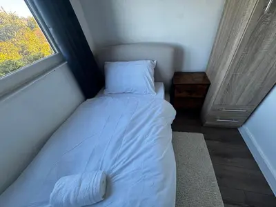 a bed in a small room with a window at 4BR Home near Airport & City Centre Free Parking in Edinburgh