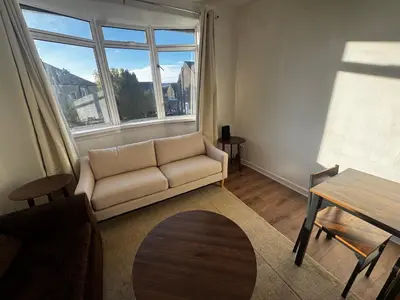 a living room with a couch and a table at 4BR Home near Airport & City Centre Free Parking in Edinburgh