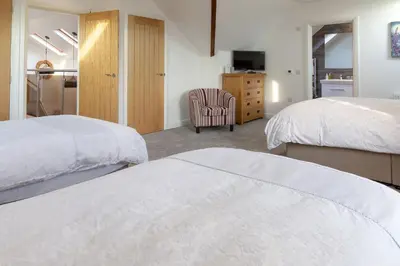 a hotel room with two beds and a chair at Sunset View in Innellan