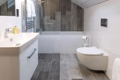 a white bathroom with a tub and a toilet and a sink at Sunset View in Innellan