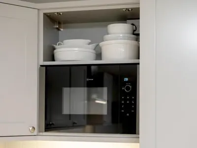 a microwave oven with dishes in a kitchen at Pass the Keys Spacious Bright Modern Edinburgh City Flat in Edinburgh