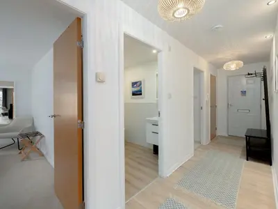 a hallway with a door leading to a living room at Pass the Keys Spacious Bright Modern Edinburgh City Flat in Edinburgh