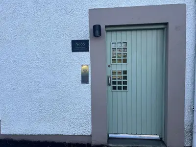 a door to a building with a sign on it at Fifty Five on Gilmour Street in Eaglesham