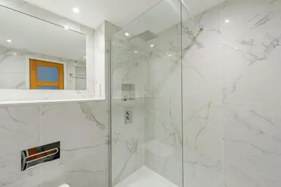 a bathroom with a shower with a glass door at Lovely Edinburgh Home - Craighouse Gardens in Edinburgh