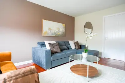 a living room with a blue couch and a table at 4 BDR House By Caledonia Luxe Stays Short Lets & Serviced Accommodation Livingston in Livingston