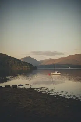 a boat sitting in the middle of a body of water at NICHT' Apartments Inveraray Town Centre in Inveraray
