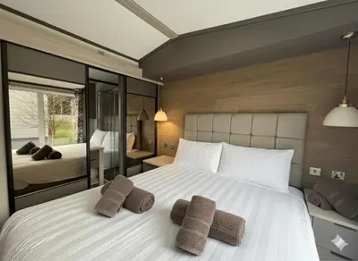 a bedroom with a large white bed with two towels at Luxury Lodge