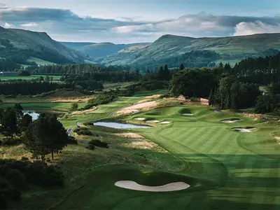 an aerial view of a golf course with mountains in the background at Luxury Lodge