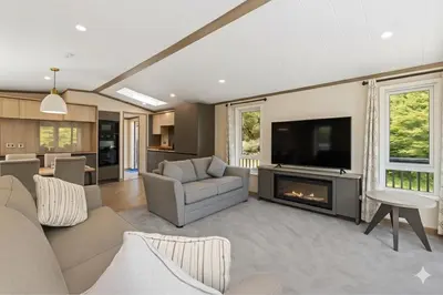 a living room with a fireplace and a tv at Luxury Lodge
