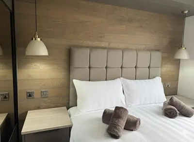 a bedroom with a white bed with towels on it at Luxury Lodge