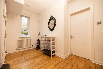 a hallway with a white door and a mirror at Knightswood in Knightswood