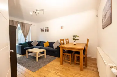 a living room with a blue couch and a table at Knightswood in Knightswood