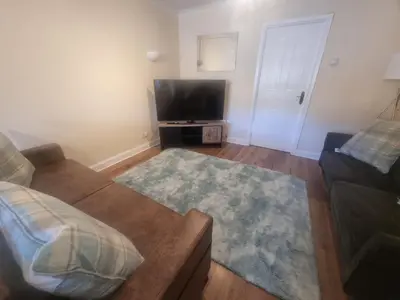 a living room with a couch and a flat screen tv at Cheerful two bedroom home in Dunfermline in Dunfermline