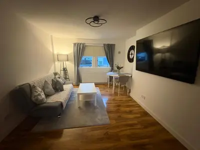 a living room with a couch and a table at Premium Village Stay near Train & Loch in Lochwinnoch