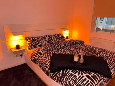 a bedroom with a bed with zebra sheets and two lamps at Premium Village Stay near Train & Loch in Lochwinnoch