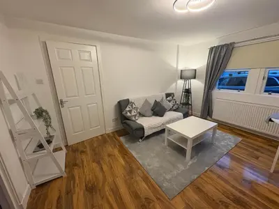 a living room with a couch and a table at Premium Village Stay near Train & Loch in Lochwinnoch