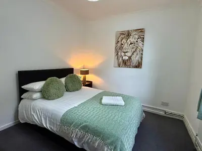 a bedroom with a bed with a painting on the wall at Clapham Road Apartment in Moffat