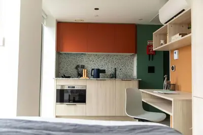 a kitchen with a counter and chairs in a room at For Students Only Martha Street Glasgow in Glasgow