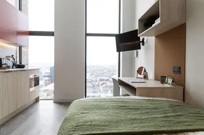 a bedroom with a bed and a desk with a large window at For Students Only Martha Street Glasgow in Glasgow