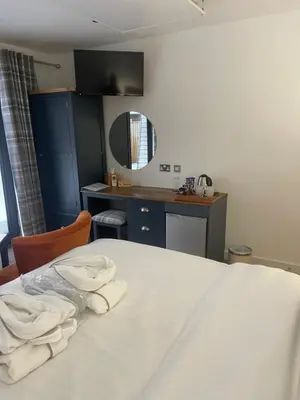 a room with a bed with white towels on it at Whitemoss Lodge in Dunning