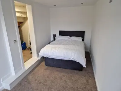 a bedroom with a bed with a white comforter at Edinburgh West Luxury 5 Bedroom Home in Edinburgh