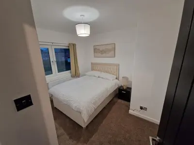a white bedroom with a bed and a window at Edinburgh West Luxury 5 Bedroom Home in Edinburgh