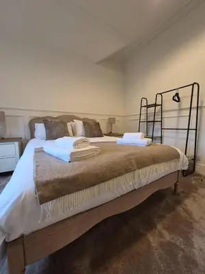 a bedroom with a bed with two towels on it at Kirkgate 2 bed - Coorie Doon Stays in Irvine
