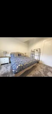 a bedroom with a bed with a blue comforter at Kirkgate 2 bed - Coorie Doon Stays in Irvine