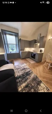 a living room with a couch and a large window at Kirkgate 2 bed - Coorie Doon Stays in Irvine