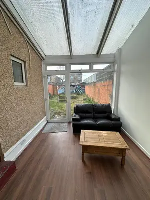 a living room with a black couch and a coffee table at Victorian 5 Bedroom House Free Parking SSE Central in Glasgow