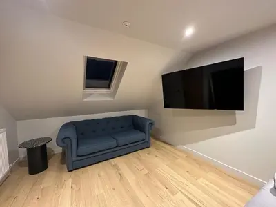 a living room with a blue couch and a flat screen tv at 2-Bed - Sleeps 6 - Pet Friendly with Free Parking in Falkirk