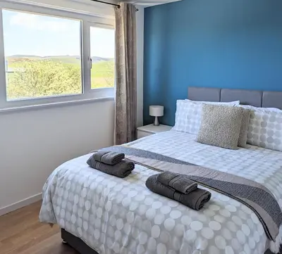 a bedroom with a bed with two towels on it at Fairway house in Campbeltown