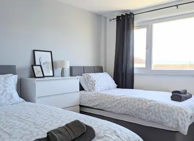 a bedroom with two beds and a window at Fairway house in Campbeltown