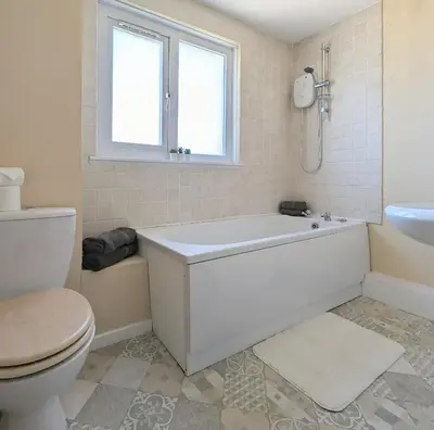 a bathroom with a tub and a toilet and a sink at Fairway house in Campbeltown
