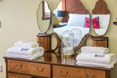 a bedroom with a bed and a table with towels at Blà Bheinn by Birch Stays in Dunollie