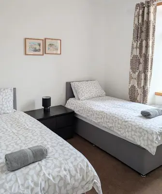 a bedroom with two twin beds and a window at Whisky Row in Campbeltown
