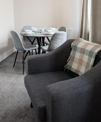 a living room with a table and a couch and chairs at Whisky Row in Campbeltown