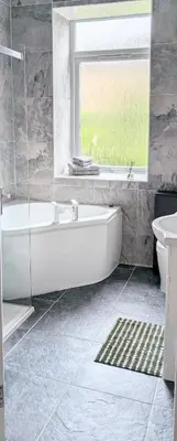 a bathroom with a tub and a sink and a window at Whisky Row in Campbeltown
