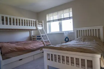 a bedroom with two bunk beds and a window at Ardlui House Gardens in Hamilton