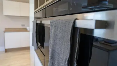 a kitchen with a towel hanging on the oven at Ardlui House Gardens in Hamilton
