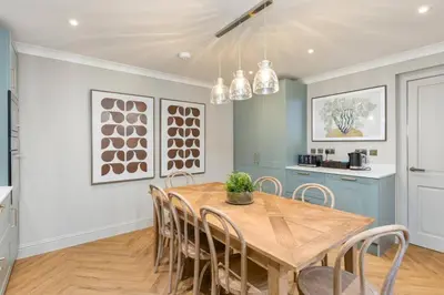 a kitchen and dining room with a wooden table and chairs at The Kings Park Luxury Residence in Stirling