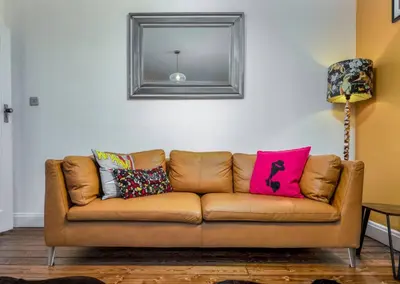a brown couch in a living room with a mirror at Tranquil Glasgow Retreat in Glasgow
