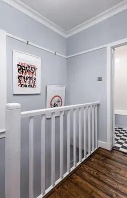 a white staircase in a room with white walls and wood floors at Tranquil Glasgow Retreat in Glasgow