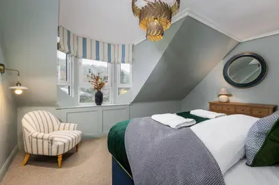 a bedroom with a bed and a chair and a window at Ledi Lookout Callander in Stirling