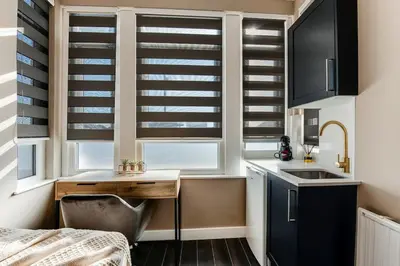 a kitchen with black and white shuttered windows and a sink at Stylish Studio Retreat in Ideal Location in Moffat