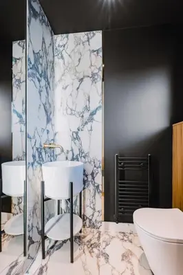 a bathroom with a white sink and a tub at JW Executive ApartHouse in Glasgow