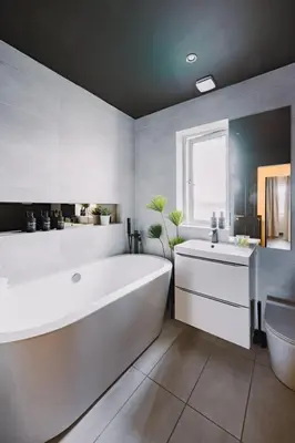 a bathroom with a large white tub and a sink at JW Executive ApartHouse in Glasgow